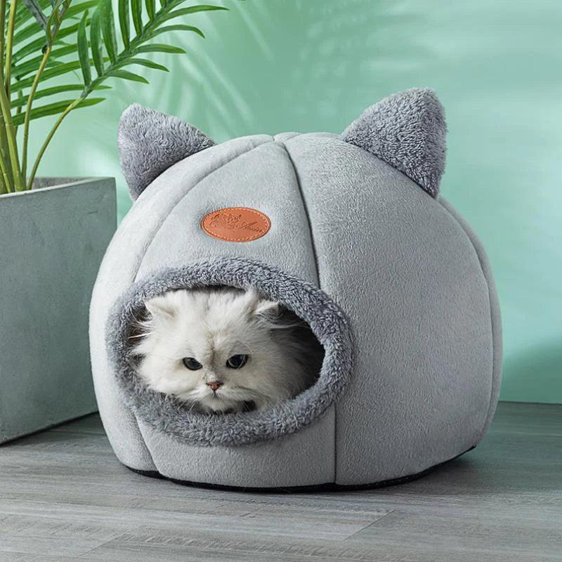 Cozy gray cat cave bed with fluffy white cat peeking out, perfect for indoor pet comfort and sleep.