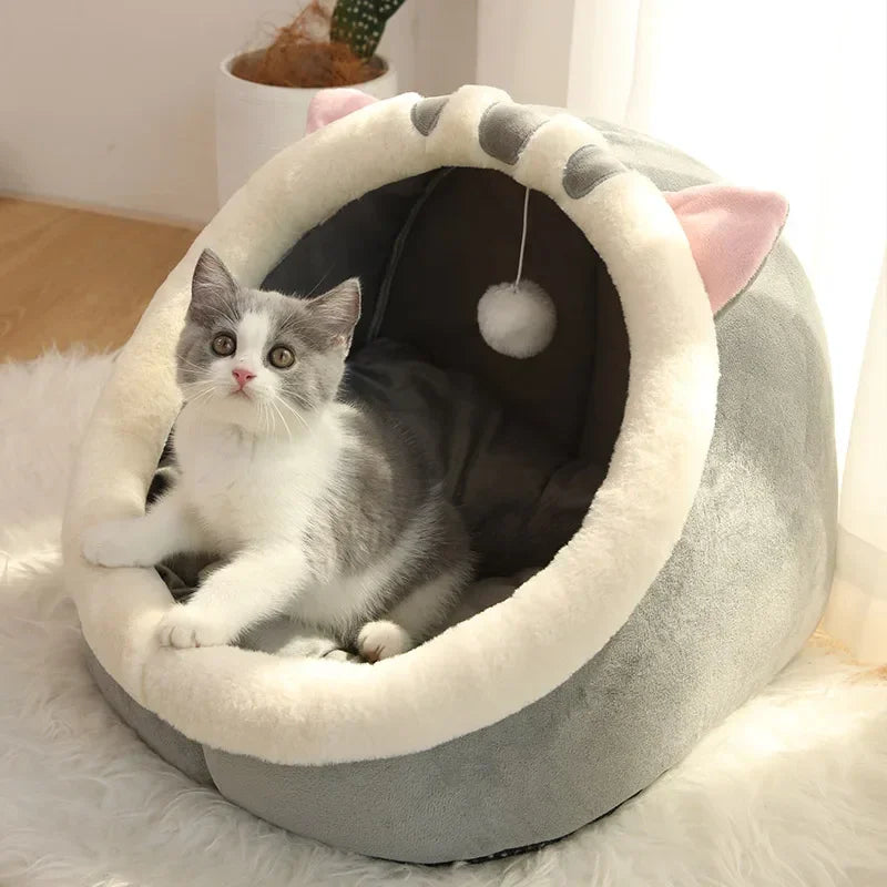 Cozy cat bed with plush cat ears and hanging pom-pom toy, perfect for cats and kittens