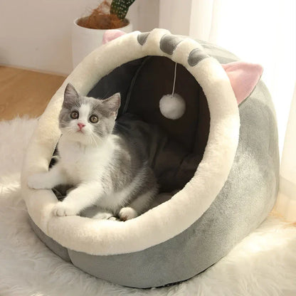 Cozy cat bed with plush cat ears and hanging pom-pom toy, perfect for cats and kittens
