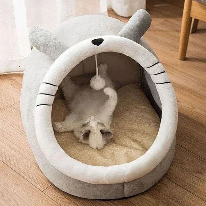 Cozy cat bed with playful kitten inside, featuring soft gray fabric and built-in toy for interactive fun.